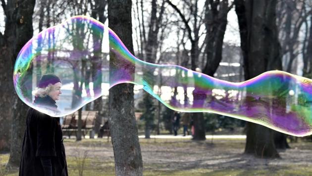 A woman walks next to a soap bubble made by a street artist in the center of Ukrainian capital of Kiev on a sunny day. (Sergei SUPINSKY / AFP) A woman walks next to a soap bubble made by a street artist in the center of Ukrainian capital of Kiev on a sunny day. (Sergei SUPINSKY / AFP)