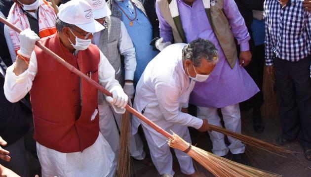 Chief minister Trivendra Singh Rawat wields a broom during the Swachh Bharat drive in Dehradun on Monday.(Vinay Santosh Kumar/HT)