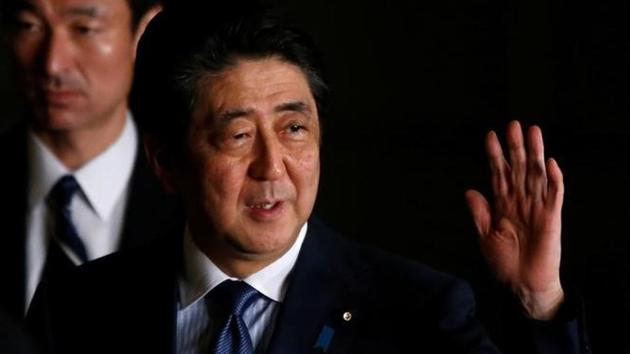 Japan's Prime Minister Shinzo Abe raises his hand as he walks at his official residence in Tokyo on March 16.(Reuters Photo)