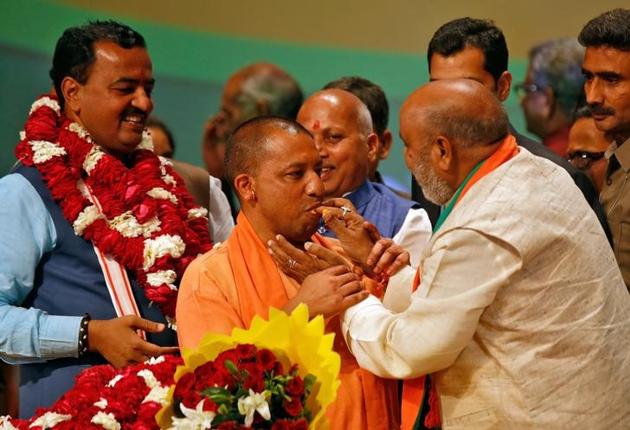 Bharatiya Yogi Adityanath is offered sweets after being elected Uttar Pradesh chief mInister on Saturday.(Reuters file)