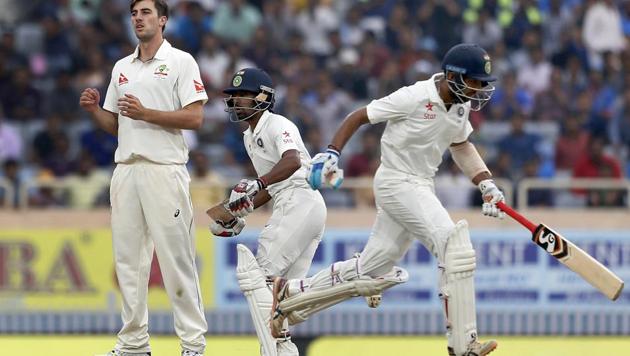 Australia's Pat Cummins watches as India's Wriddhiman Saha, center, and Cheteshwar Pujara run between the wickets on Day 4 of the third cricket Test in Ranchi on March 19.(AP)