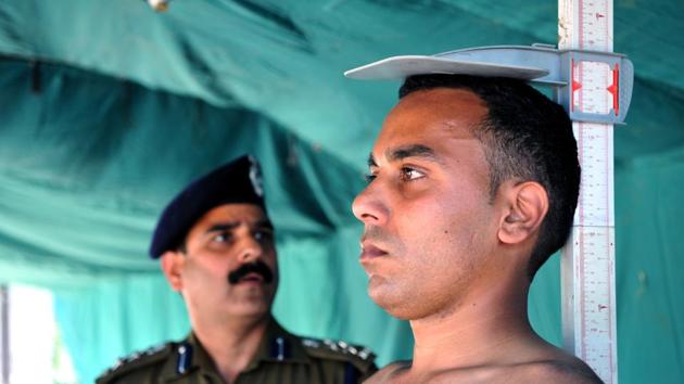 A police officer measures the height of a candidate during Jammu and Kashmir Police (JKP)  recruitment rally, in Jammu, on Monday. (Nitin Kanotra / Hindustan Times) 