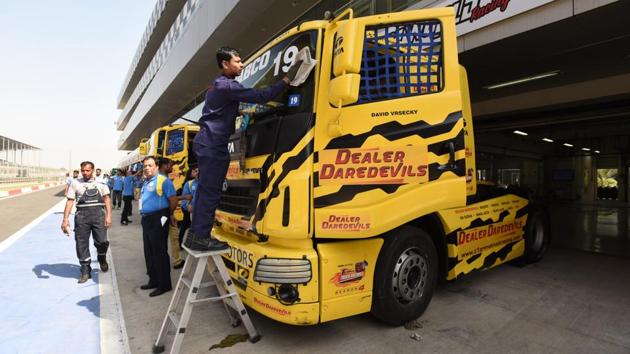Crew members cleaning the Truck during T1 Prima truck racing championship at The Buddh International Circuit in Greater Noida. (Virendra Singh Gosain/HT PHOTO)