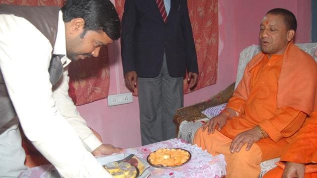 A follower serves papaya and other breakfast to Uttar Pradesh chief minister Aditya Nath.(HT Photo)