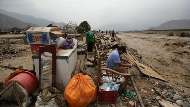 A man sits with his belongings after the floods. The rains have overwhelmed the drainage system in the cities along Peru’s Pacific coast and the health ministry has started fumigating around the pools of water that have formed in the streets to kill mosquitoes that carry diseases like dengue. (Mariana Bazo/REUTERS) 