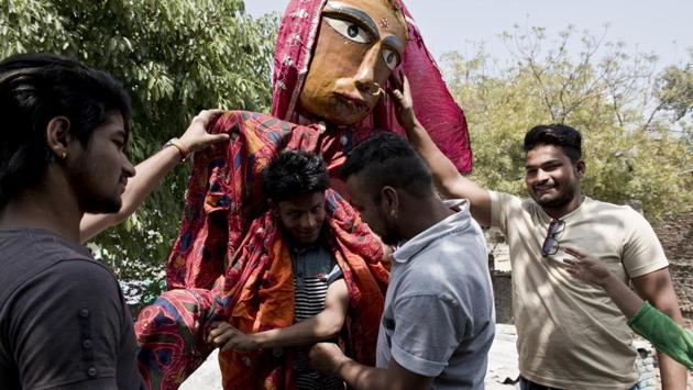 Vicky Bhatt (in grey shirt), a local puppeteer from Kathputli Colony helps his friend in wearing a puppet at Kathputli Colony. (Saumya Khandelwal/HT PHOTO) Vicky Bhatt (in grey shirt), a local puppeteer from Kathputli Colony helps his friend in wearing a puppet at Kathputli Colony. (Saumya Khandelwal/HT PHOTO)