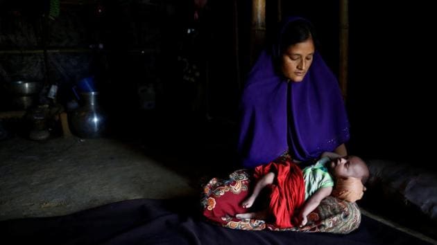 Rajuma Begum, 28, poses for a photograph with her one-month-old son Raihan inside their shelter in Kutupalang unregistered refugee camp in Cox’s Bazar. ‘I fled to Bangladesh because of fear, because I needed to save my children. I was pregnant and suffering from fever while crossing the border. I also have an 11-month-old boy, so it was very difficult to reach the border from our village Wabek in Myanmar. I had to rest frequently. After six hours of horrible walking finally we reached the border at 2am and crossed the border after paying a broker,’ Rajuma Begum said. (Mohammad Ponir Hossain/REUTERS)
