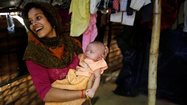 Noor Kayes, 18, smiles as she holds her 26-day-old unnamed daughter at their home in Kutupalang unregistered refugee camp in Cox’s Bazar. Noor Kayes fled to Bangladesh with her parents from Poachong village in Myanmar two months ago after her husband was killed by the military. (Mohammad Ponir Hossain/REUTERS)