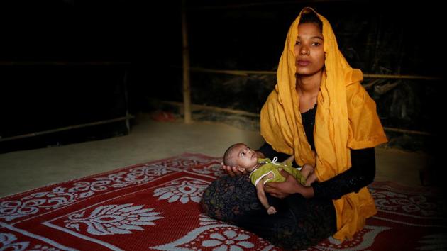 Sanwara Begum, 20, poses for a photograph with her 25-day-old daughter Aasma inside their shelter in Kutupalang unregistered refugee camp in Cox’s Bazar. Sanwara Begum fled to Bangladesh from Khyeri Prang village in Myanmar, with her husband around two and a half months ago. Her husband Rafiqullah now works as a day labourer in Cox’s Bazar. ‘No one wants to leave their own home. We have come to Bangladesh only to save our lives. Myanmar is our home, we will move to Myanmar immediately if the situation becomes stable,’ Sanwara said. (Mohammad Ponir Hossain/REUTERS)