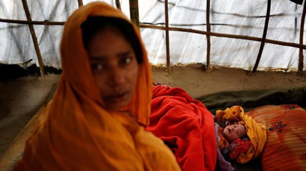 Noor Begum, 26, sits next to her one-day-old daughter Sumaiya as she poses for a photograph inside their shelter in Balukhali unregistered refugee camp in Cox’s Bazar. Noor Begum came to the camp one-and-a-half months ago from Nagpura village with her husband Jahangir Alom. (Mohammad Ponir Hossain/REUTERS)