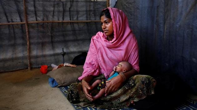 Asmot Ara, 18, holds her seven-day-old unnamed daughter as she poses for a photograph inside their shelter in Balukhali unregistered refugee camp in Cox’s Bazar, Bangladesh. Asmot Ara said she came to the camp one month ago with neighbours from Nagpura village in Myanmar after her father-in-law was killed and their home burnt down by the Myanmar military. (Mohammad Ponir Hossain/REUTERS)