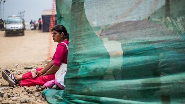 Local residents affected by the flash floods sit by tents set up by volunteers and authorities in Huachipa district, east of Lima. Lima has been without water service since the beginning of the week.  (Ernesto Benavides/AFP) 