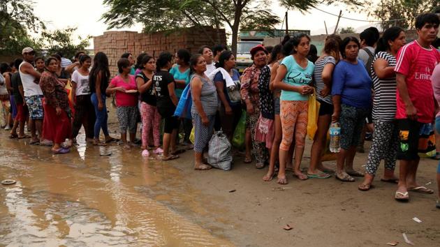 Residents wait in line for food at Cajamarquilla, Lima. The government has deployed the armed forces to help police control public order in the 811 cities that have declared an emergency. (Mariana Bazo/REUTERS) 