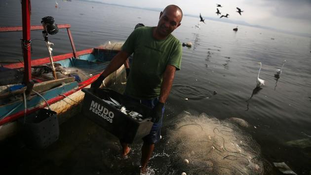 A fisherman carries a box of fishes at the Bancarios beach, ahead of World Water Day, in the Guanabara bay in Rio de Janeiro, Brazil. (Pilar Olivares / REUTERS) A fisherman carries a box of fishes at the Bancarios beach, ahead of World Water Day, in the Guanabara bay in Rio de Janeiro, Brazil. (Pilar Olivares / REUTERS)