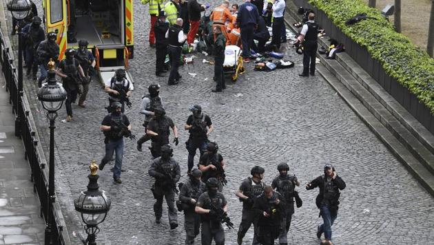 Armed police walk past emergency services attending to injured people on the floor outside the Houses of Parliament, London, on March 22, 2017.(AP) Armed police walk past emergency services attending to injured people on the floor outside the Houses of Parliament, London, on March 22, 2017.(AP)