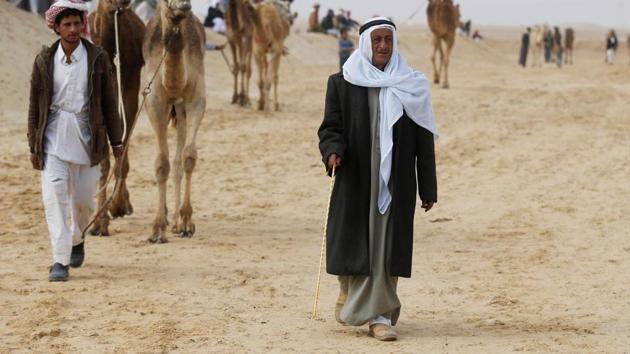 Sheikh Suleiman Abu Shukri walks during the opening of the International Camel Racing festival at the Sarabium desert. (Amr Abdallah Dalsh / Reuters) Sheikh Suleiman Abu Shukri walks during the opening of the International Camel Racing festival at the Sarabium desert. (Amr Abdallah Dalsh / Reuters)
