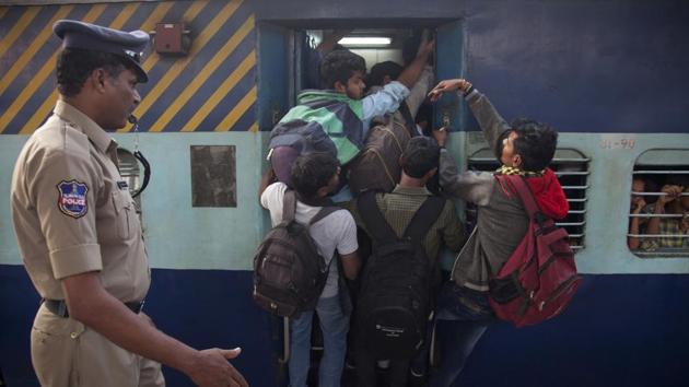 Passengers hang from the door of an overcrowded train in Hyderabad. Railway minister Suresh Prabhu will announce an ambitious plan to provide reserved berths to all train. (AP file photo) Passengers hang from the door of an overcrowded train in Hyderabad. Railway minister Suresh Prabhu will announce an ambitious plan to provide reserved berths to all train. (AP file photo)
