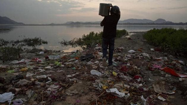 A devotee wearing a helmet carries flowers and other worship material before throwing them in the river Brahmaputra on the eve of World Water Day in Gauhati. (Anupam Nath / AP) A devotee wearing a helmet carries flowers and other worship material before throwing them in the river Brahmaputra on the eve of World Water Day in Gauhati. (Anupam Nath / AP)