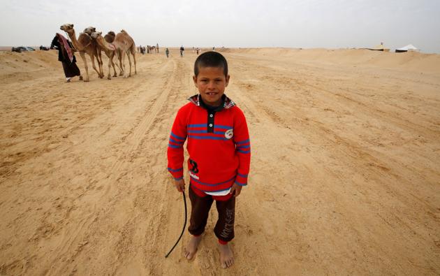Fahad, an 8-year-old jockey, looks on during the opening of the International Camel Racing festival . (Amr Abdallah Dalsh / Reuters) Fahad, an 8-year-old jockey, looks on during the opening of the International Camel Racing festival . (Amr Abdallah Dalsh / Reuters)