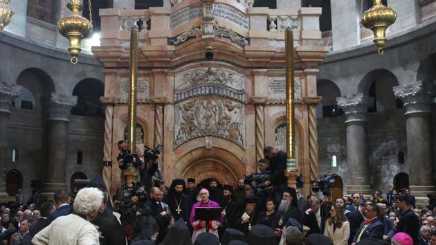 Christian clergymen and other guests attend a ceremony next to the Edicule at the Church of the Holy Sepulchre. The newly renovated tomb, where Jesus’s body is believed to have been interred after crucifixion, was unveiled at a ceremony after nine months of painstaking restoration work costing about $4 million. (Menahem Kahana/AFP) Christian clergymen and other guests attend a ceremony next to the Edicule at the Church of the Holy Sepulchre. The newly renovated tomb, where Jesus’s body is believed to have been interred after crucifixion, was unveiled at a ceremony after nine months of painstaking restoration work costing about $4 million. (Menahem Kahana/AFP)