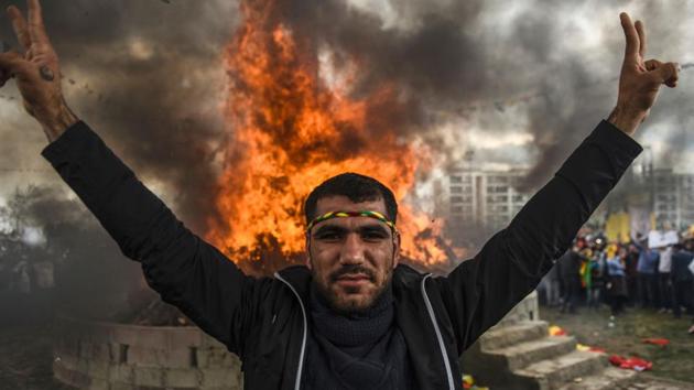 A Kurdish man flashes the victory sign in front of a bonfire. But that summer a fragile peace process collapsed as the PKK ended a ceasefire amid mutual acrimony, reviving an insurgency that has left hundreds of members of the security forces dead. (Bulent Kilic/AFP) A Kurdish man flashes the victory sign in front of a bonfire. But that summer a fragile peace process collapsed as the PKK ended a ceasefire amid mutual acrimony, reviving an insurgency that has left hundreds of members of the security forces dead. (Bulent Kilic/AFP)