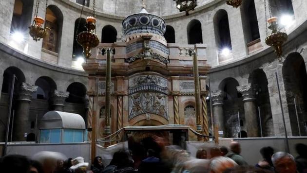Visitors stand near the newly restored Edicule, the ancient structure housing the tomb, which according to Christian belief is where Jesus's body was anointed and buried, seen at the completion of months of restoration works, at the Church of the Holy Sepulchre in Jerusalem's Old City.(Reuters)