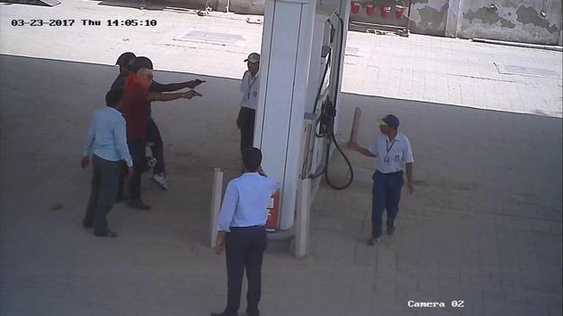 A video grab of three men pointing firearms at the petrol pump staff in Haileymandi, Pataudi, on Thursday. A video grab of three men pointing firearms at the petrol pump staff in Haileymandi, Pataudi, on Thursday.