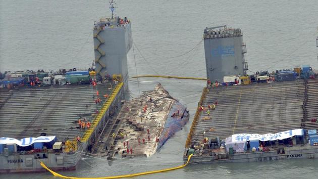 Workers prepare to lift the sunken Sewol ferry in waters off Jindo, South Korea. Several relatives watched the much-anticipated operation unfolding from a boat near the site. (AP/PTI) Workers prepare to lift the sunken Sewol ferry in waters off Jindo, South Korea. Several relatives watched the much-anticipated operation unfolding from a boat near the site. (AP/PTI)