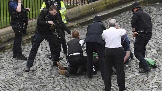 A policeman points a gun at a man on the floor while standing on a knife as emergency services attend the scene outside the Palace of Westminster, London, on March 22, 2017. A man with a knife attacked a police officer at Parliament and was shot by officers. (AP) A policeman points a gun at a man on the floor while standing on a knife as emergency services attend the scene outside the Palace of Westminster, London, on March 22, 2017. A man with a knife attacked a police officer at Parliament and was shot by officers. (AP)