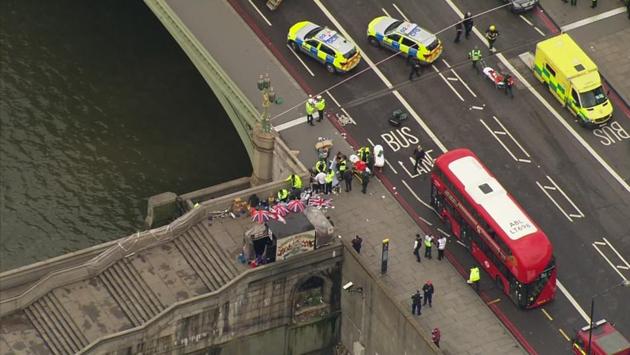 In this image taken from video emergency personnel gather around a body on the southside of Westminster Bridge that leads to the Houses of Parliament in London, Wednesday, March 23, 2017 after the House of Commons sitting was suspended as witnesses reported sounds like gunfire outside. (ITN via AP)