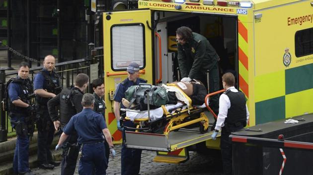 An attacker is treated by emergency services outside the Houses of Parliament in London, Wednesday, March 22, 2017. (Stefan Rousseau / AP)