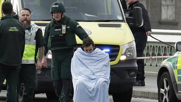 An injured man sits covered with a blanket as emergency services staff provide medical attention to injured people on the south side of Westminster Bridge, close to the Houses of Parliament in London, Wednesday, March 22, 2017. (Matt Dunham / AP)