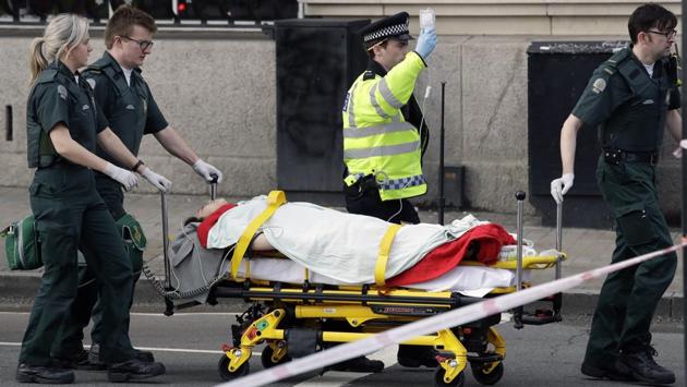 Emergency services transport an injured person to an ambulance, close to the Houses of Parliament in London, Wednesday, March 22, 2017. (Matt Dunham / AP)