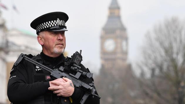 An armed police officer patrols by a security cordon set up along Whitehall by the Houses of Parliament in London.(AFP Photo)