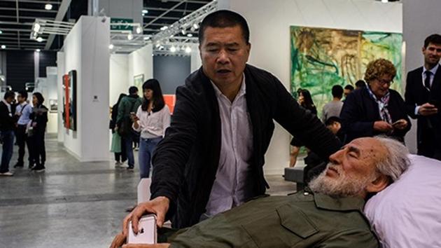 Chinese artist Shen Shaomin places his phone in the hands of a replica of Fidel Castro, part of his ‘Summit’ project, at Art Basel in Hong Kong. (AFP Photo/Anthony Wallace) Chinese artist Shen Shaomin places his phone in the hands of a replica of Fidel Castro, part of his ‘Summit’ project, at Art Basel in Hong Kong. (AFP Photo/Anthony Wallace)