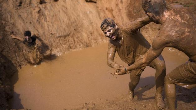 Contestants had to battle up to 22 obstacles, including swinging between ropes, climbing mud hills and crawling through icy water. (Oded Balilty/AP)