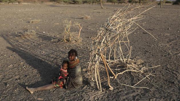 A Turkana tribeswoman holds her child next to the construction site of her cabin in a village near Loiyangalani. (Goran Tomasevic / Reuters) A Turkana tribeswoman holds her child next to the construction site of her cabin in a village near Loiyangalani. (Goran Tomasevic / Reuters)