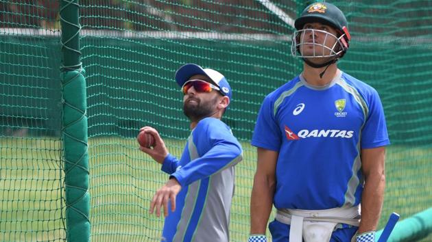 Australia's Nathan Lyon (L) is watched by teammate Ashton Agar as he throws a ball in the nets. (AFP) 