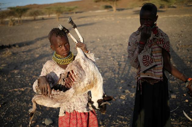 Girls carry carcasses of goats in a village. (Goran Tomasevic / Reuters) Girls carry carcasses of goats in a village. (Goran Tomasevic / Reuters)