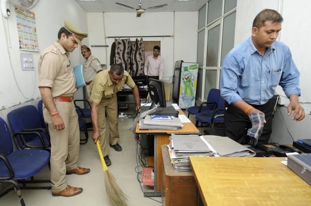 Police personnel clean the office of the superintendent of police in Noida’s Sector 6.(Sunil Ghosh/HT Photo)