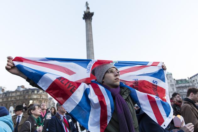 A man holds a Union Jack during a vigil at Trafalgar Square in London.(AFP)