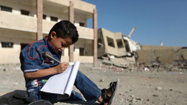 A Yemeni boy school writes as he sits outside a school on March 16, 2017, that was damaged in an air strike in the southern Yemeni city of Taez. (AFP Photo) A Yemeni boy school writes as he sits outside a school on March 16, 2017, that was damaged in an air strike in the southern Yemeni city of Taez. (AFP Photo)