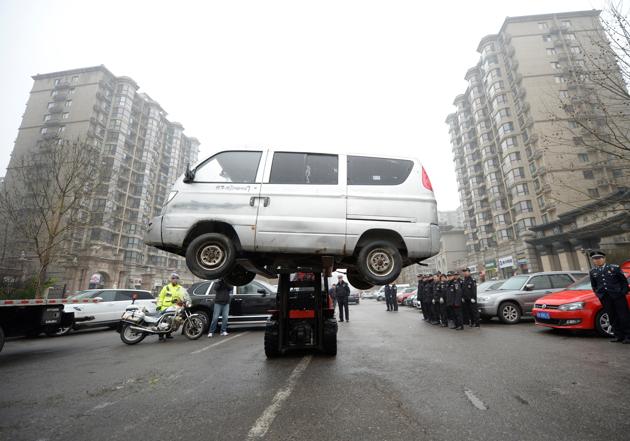 A van is towed away as the city management removes unclaimed vehicles from the roadside, in Beijing, China March 24, 2017. (REUTERS) 