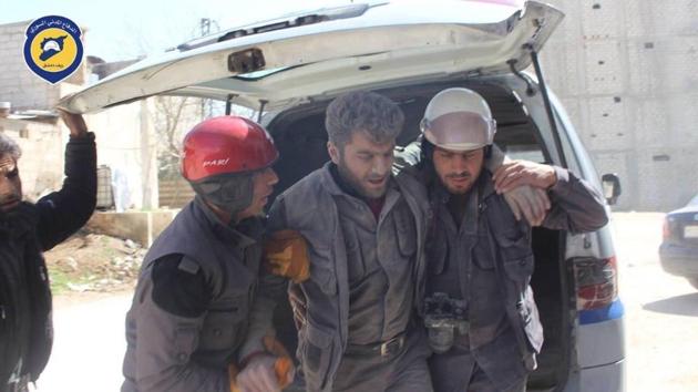 In this photo provided by the Syrian Civil Defense group known as the White Helmets, Civil Defense workers help their teammate after airstrikes hit a main street, killing many people, activists said, in the Damascus suburb of Hamouriyeh, Syria on March 25. (AP Photo) In this photo provided by the Syrian Civil Defense group known as the White Helmets, Civil Defense workers help their teammate after airstrikes hit a main street, killing many people, activists said, in the Damascus suburb of Hamouriyeh, Syria on March 25. (AP Photo)