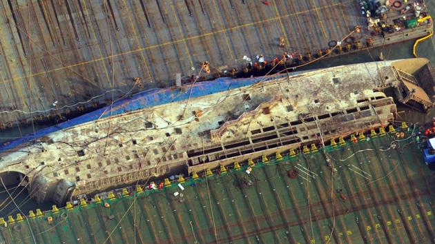This aerial image shows part of the damaged Sewol ferry between two barges after being raised during a salvage operation at sea off the southwestern island of Jindo on March 23, 2017. South Korea’s sunken Sewol ferry emerged from the waters on March 23, nearly three years after it went down with the loss of more than 300 lives and dealt a crushing blow to now-ousted president Park Geun-Hye. (AFP) 