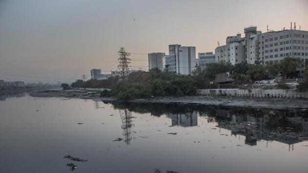 The Mithi flows dark and turgid by the swanky high-rises of the Bandra-Kurla Complex.  (Satish Bate/HT Photo) 