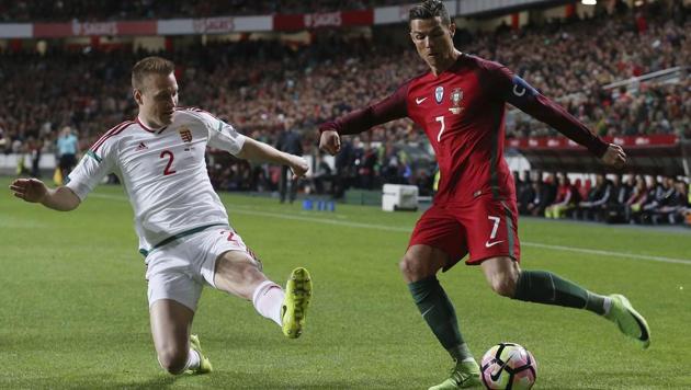 Portugal's Cristiano Ronaldo vies for the ball with Hungary's Adam Lang during a FIFA World Cup qualifier.(AP)