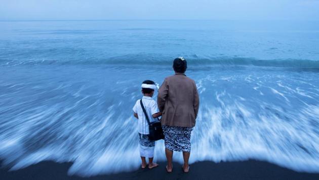 A Balinese Hindu woman holds her grandson's hand on a beach during Melasti ceremony. (Agung Parameswara/REUTERS) A Balinese Hindu woman holds her grandson's hand on a beach during Melasti ceremony. (Agung Parameswara/REUTERS)