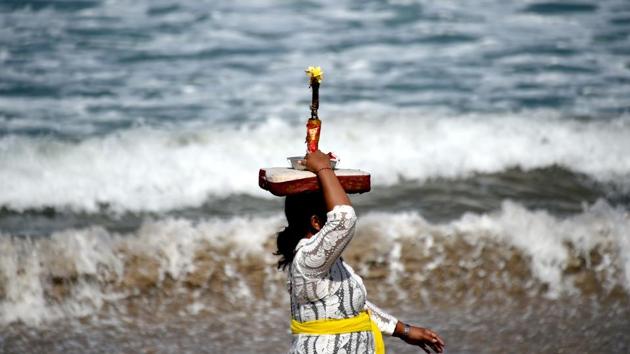 A Balinese woman carries an offering on her head for prayers during the Melasti ceremony. (Sonny Tumbelaka/AFP) A Balinese woman carries an offering on her head for prayers during the Melasti ceremony. (Sonny Tumbelaka/AFP)