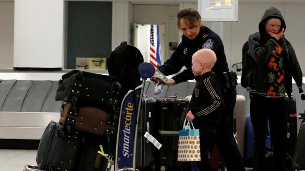 Baraka Lusambo, (R) a Tanzanian with Albinism visiting the U.S. for medical care, is escorted by walks with Teresa Piasecka, a Supervisory CBP officer for U.S. Customs and Border Protection, following his arrival at JFK International Airport in New York City. The children who arrived on Saturday were making a return trip, having outgrown prosthetics they received in the United States with the help of GMRF two years ago. (Brendan McDermid/REUTERS) Baraka Lusambo, (R) a Tanzanian with Albinism visiting the U.S. for medical care, is escorted by walks with Teresa Piasecka, a Supervisory CBP officer for U.S. Customs and Border Protection, following his arrival at JFK International Airport in New York City. The children who arrived on Saturday were making a return trip, having outgrown prosthetics they received in the United States with the help of GMRF two years ago. (Brendan McDermid/REUTERS)